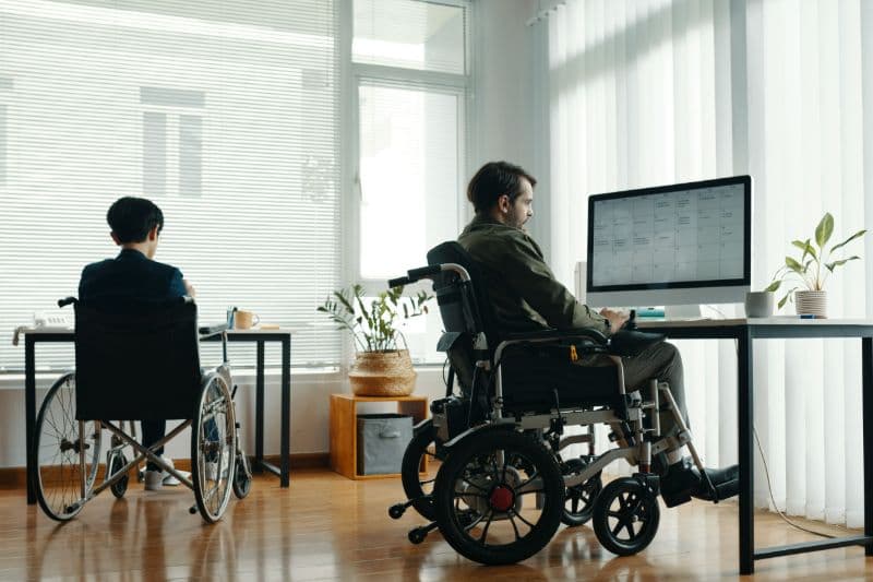 Man in wheelchair working in front of a computer